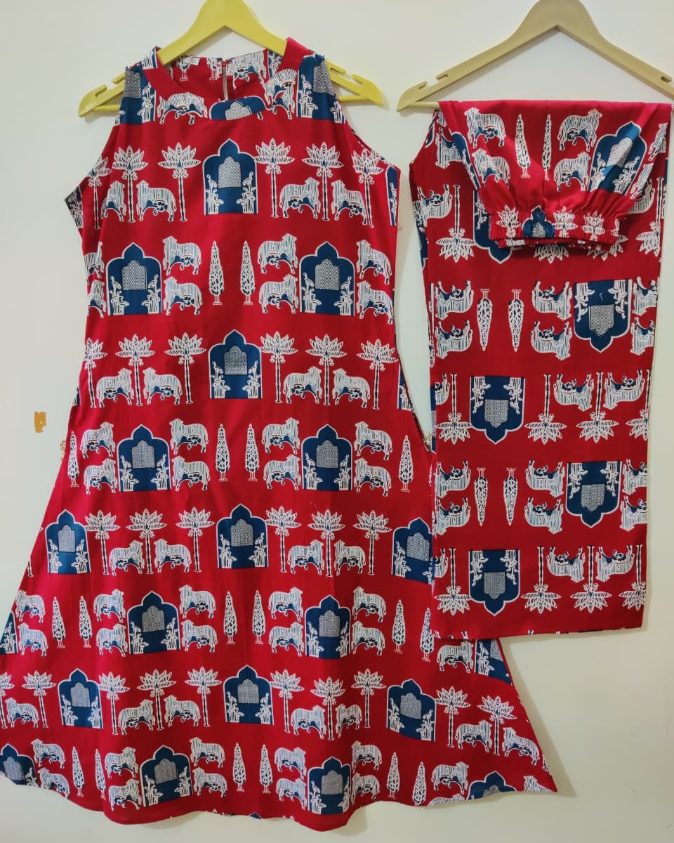 Red dress with blue and white patterns on a hanger against a white background