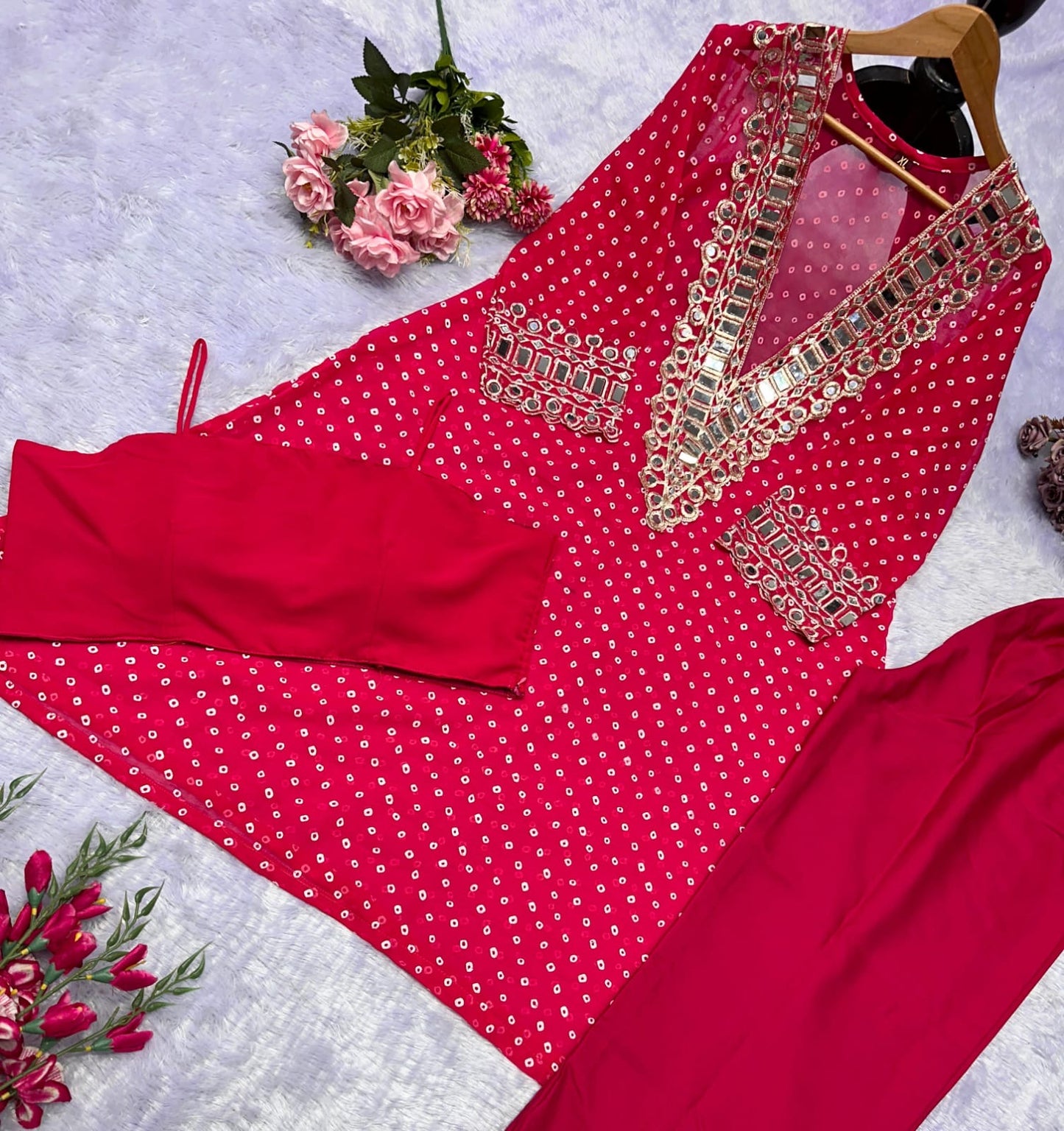Red traditional outfit with intricate gold embroidery on a light gray background
