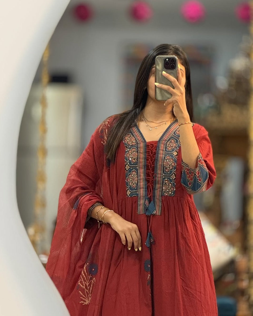 Person wearing a red embroidered dress taking a mirror selfie.