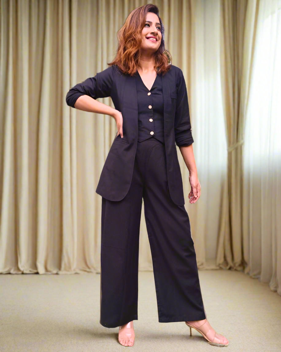 Woman in a navy blue suit standing in a garden with palm trees.