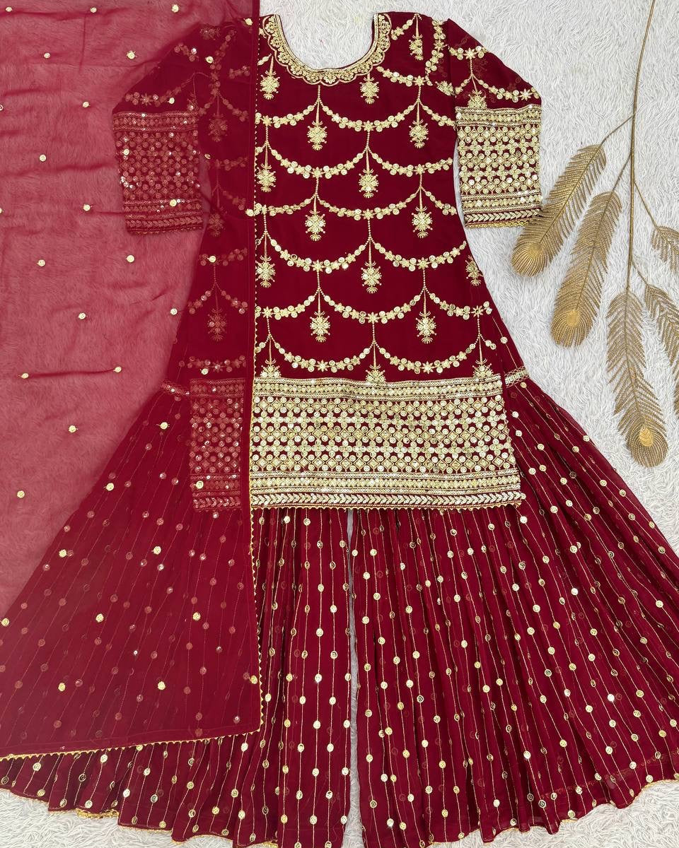 Maroon traditional outfit with gold embroidery on a light background