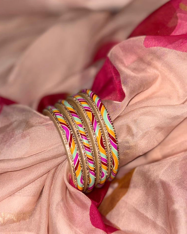 Colorful bangles on a pink fabric background