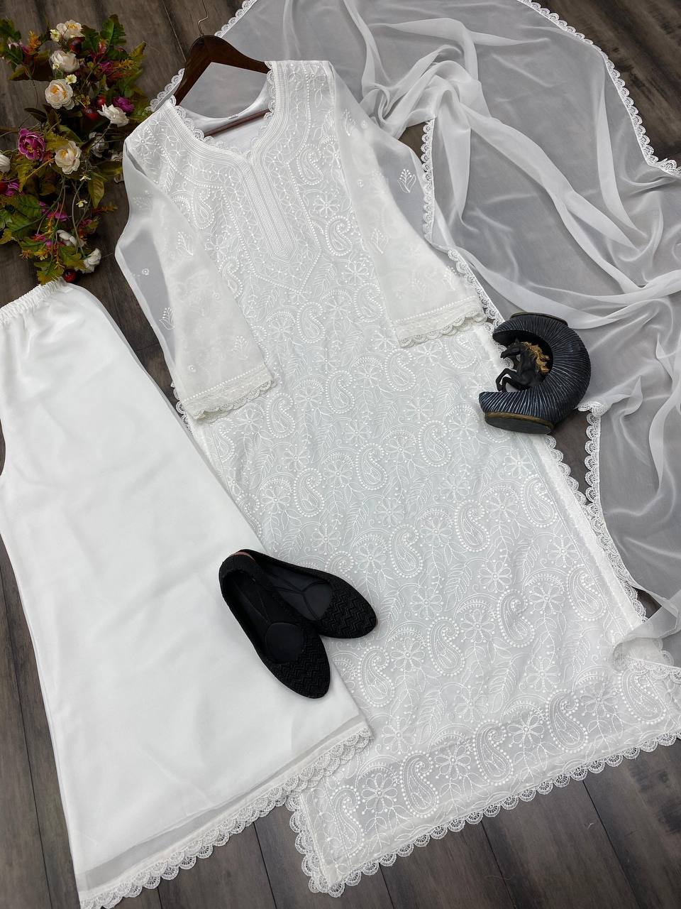 White lace dress with sheer overlay on a wooden surface
