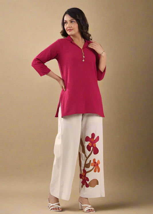 Woman wearing a red top and white pants with floral design against a colorful background