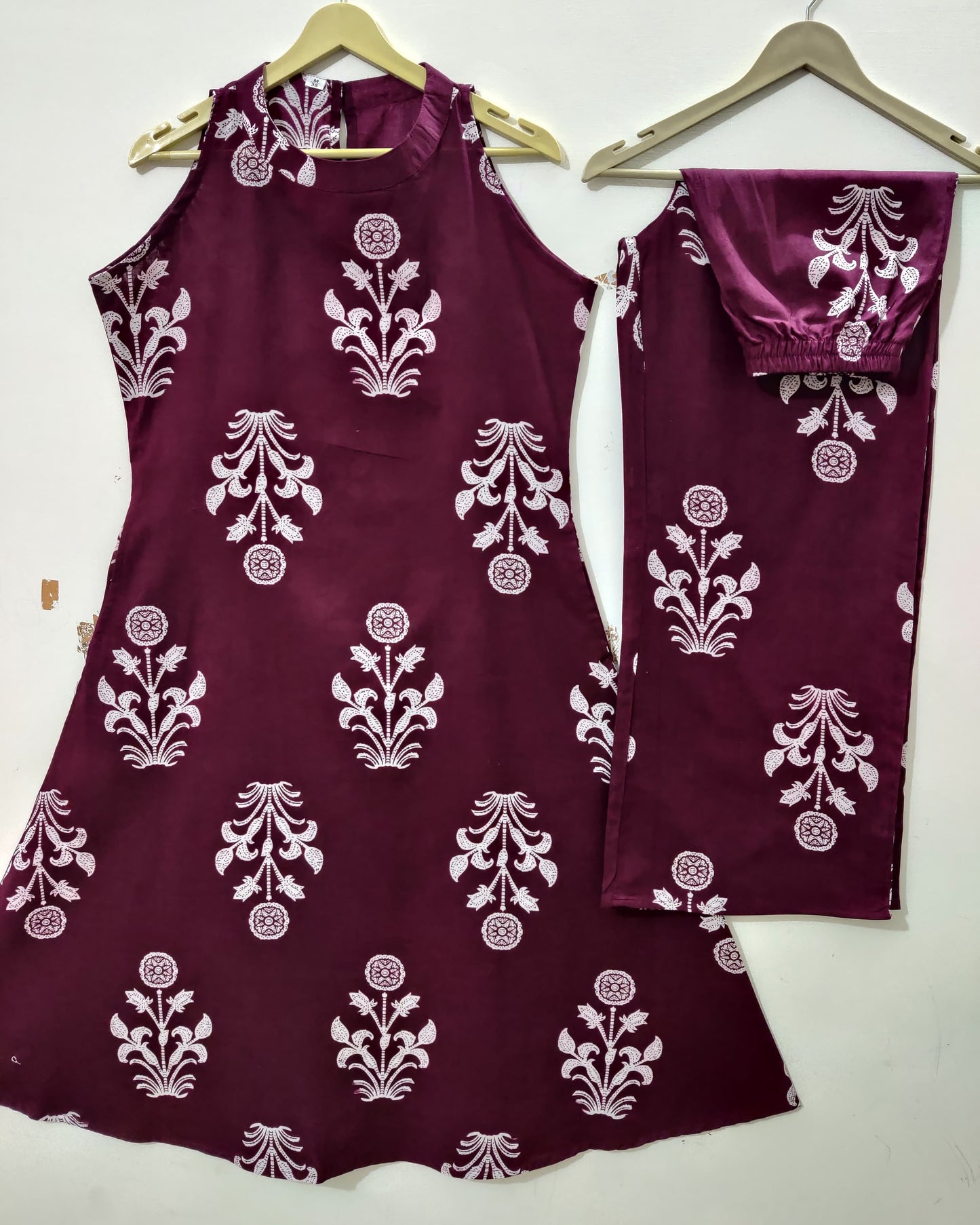 Maroon outfit with white floral patterns on a white background