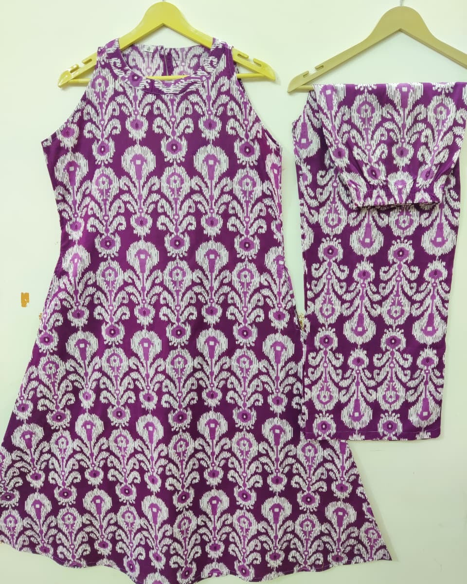 Purple and white patterned dress and pants on hangers against a white background