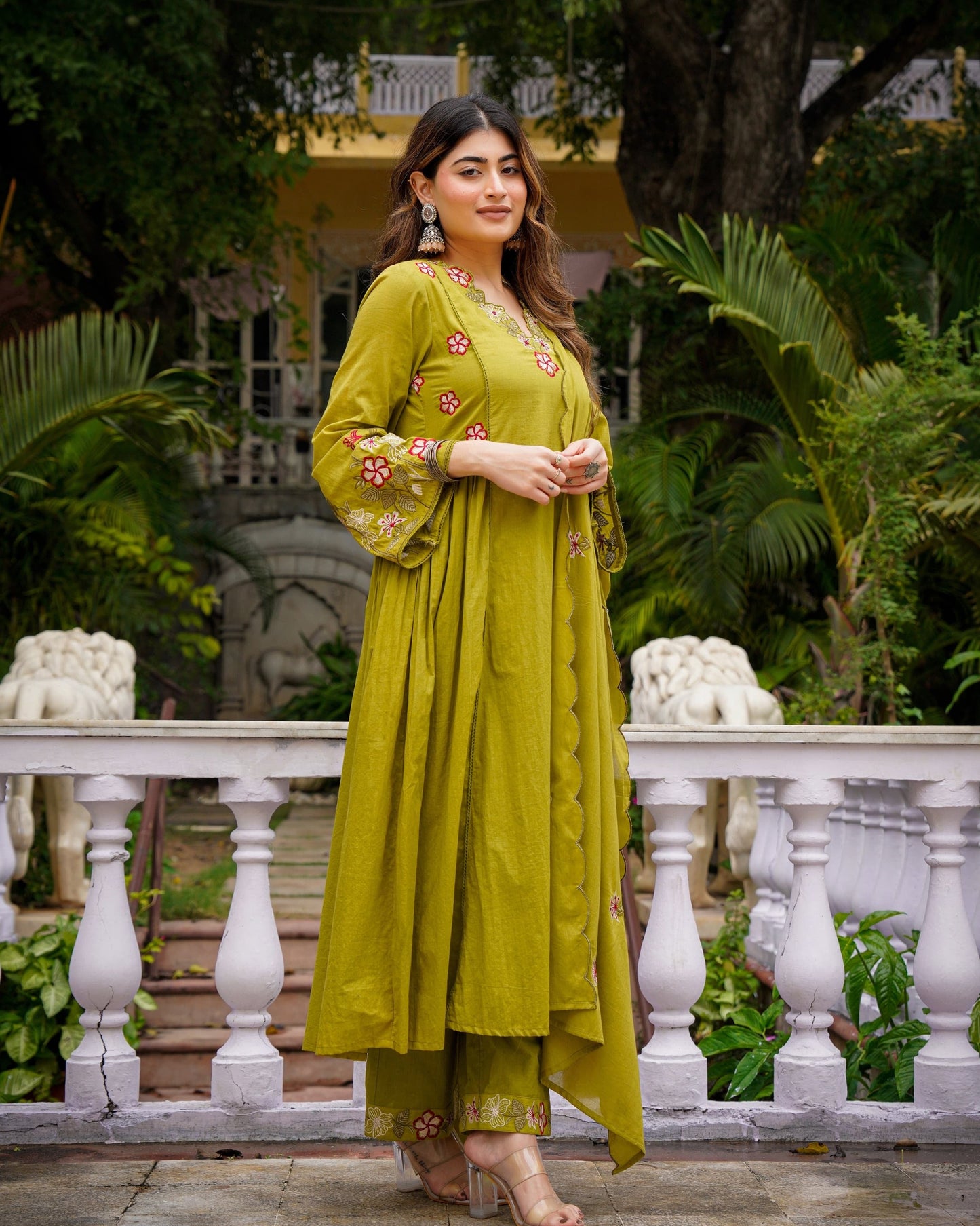 Woman in a green dress standing in a garden setting