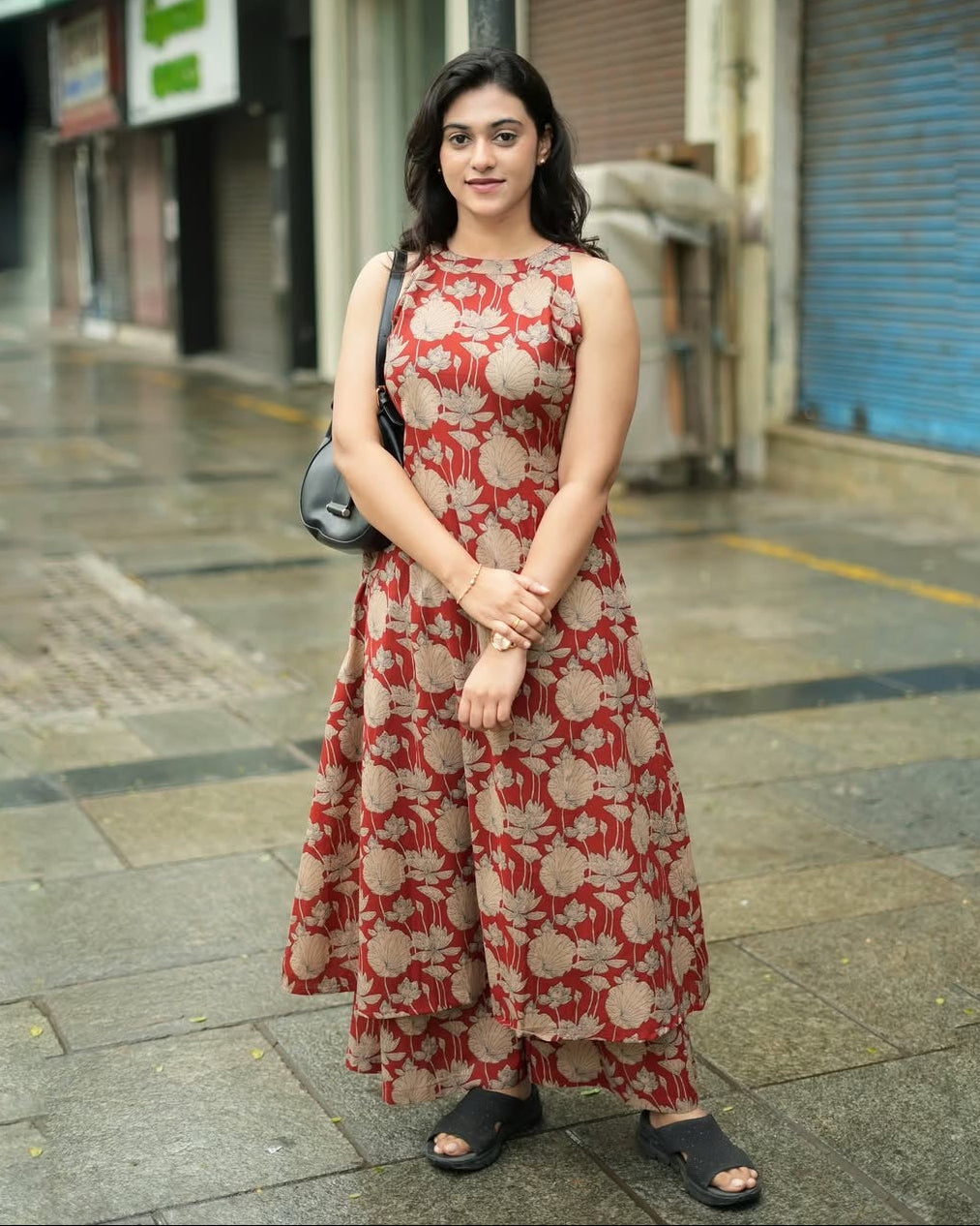 Woman in a red floral dress standing on a street
