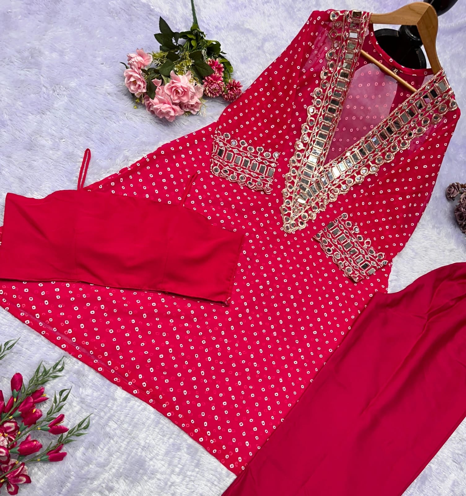 Red traditional outfit with intricate gold embroidery on a light gray background