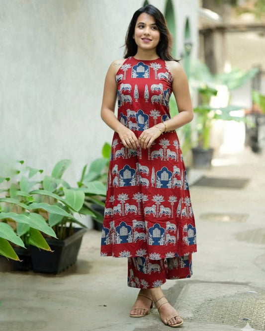 Woman wearing a red dress with elephant patterns standing outdoors.