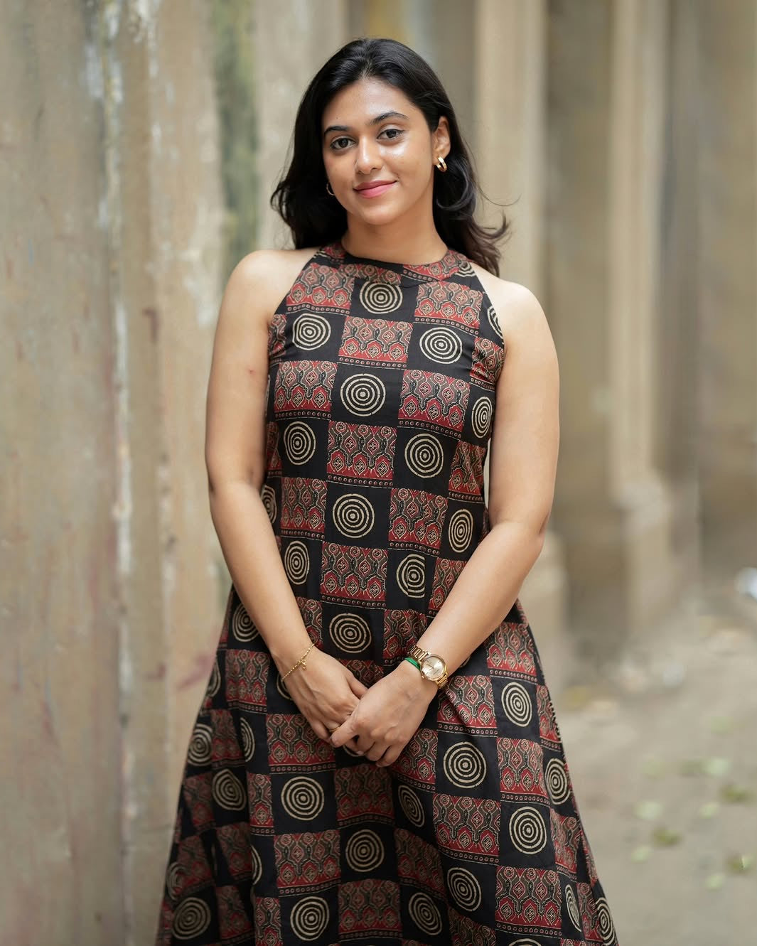 Woman wearing a patterned dress standing against a blurred background
