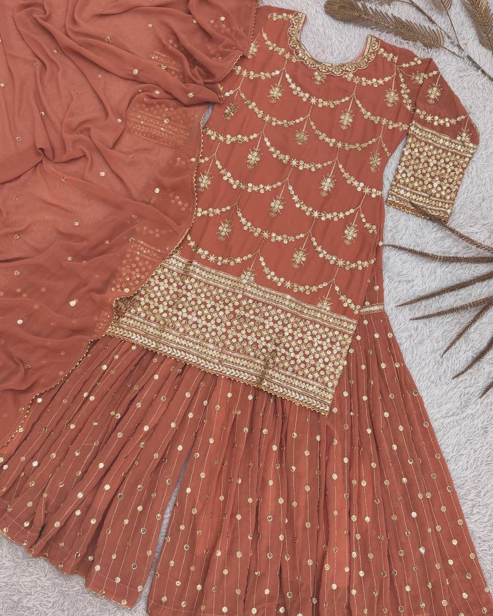 Red traditional outfit with gold embroidery on a textured surface