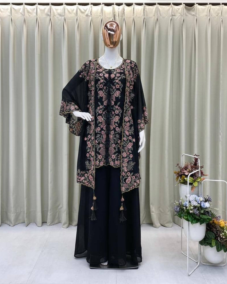 Mannequin wearing a black outfit with floral patterns against a plain background