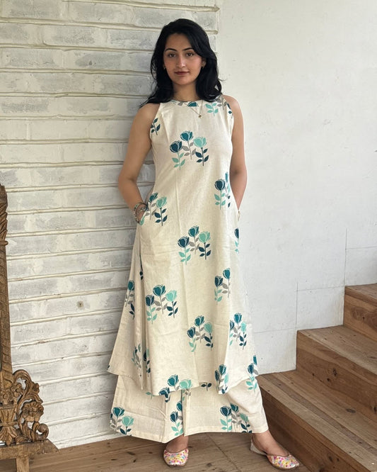 Woman wearing a floral dress standing on wooden steps with a white wall background