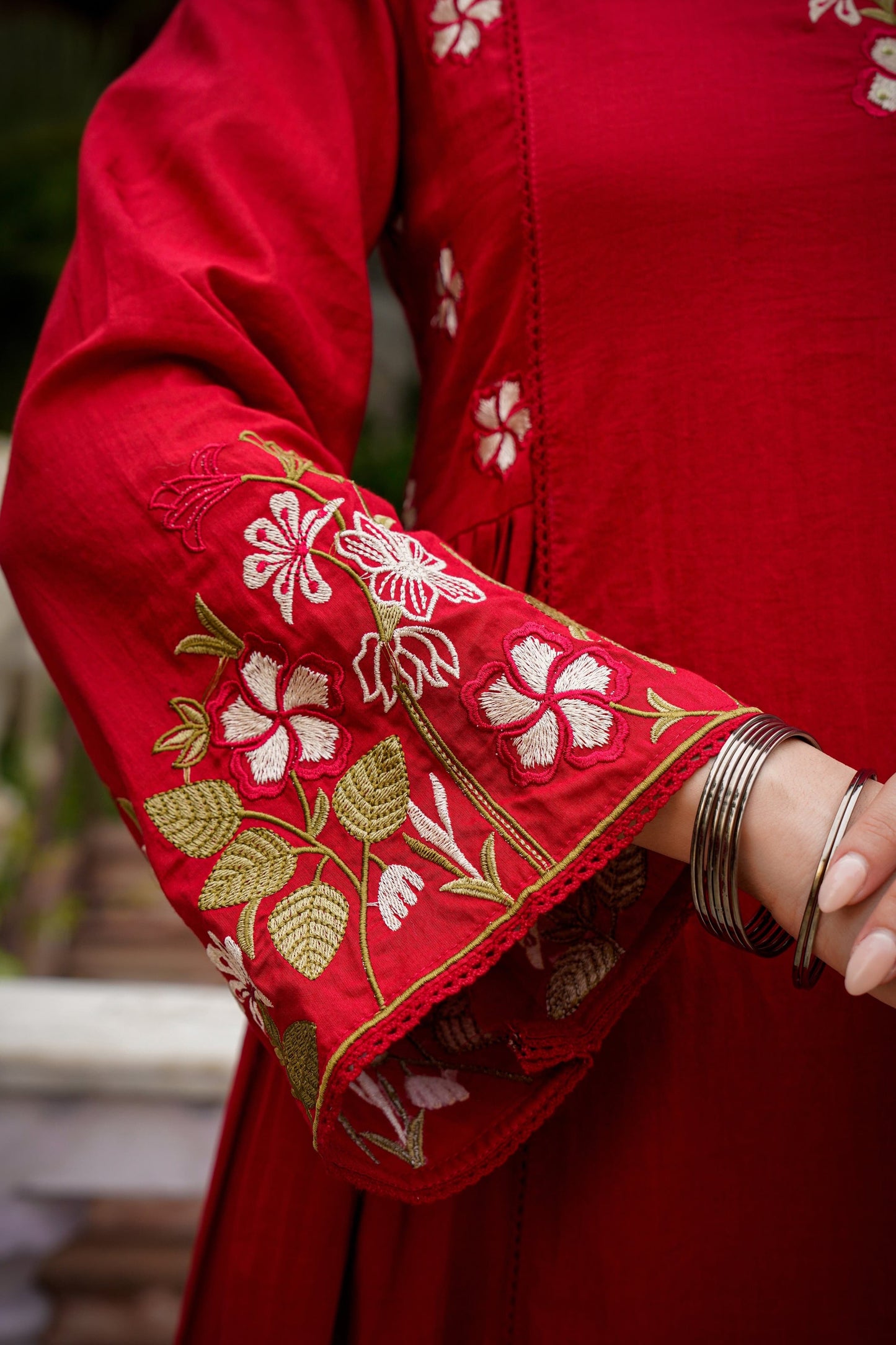 Red garment with white floral embroidery on a blurred background