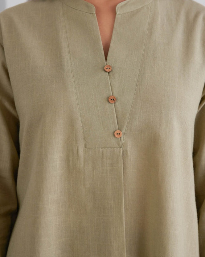 Close-up of a beige shirt with wooden buttons on a white background