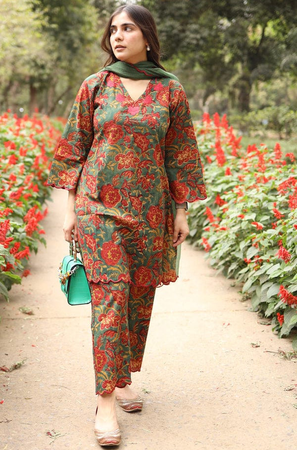 Woman in a floral outfit walking through a garden with red flowers