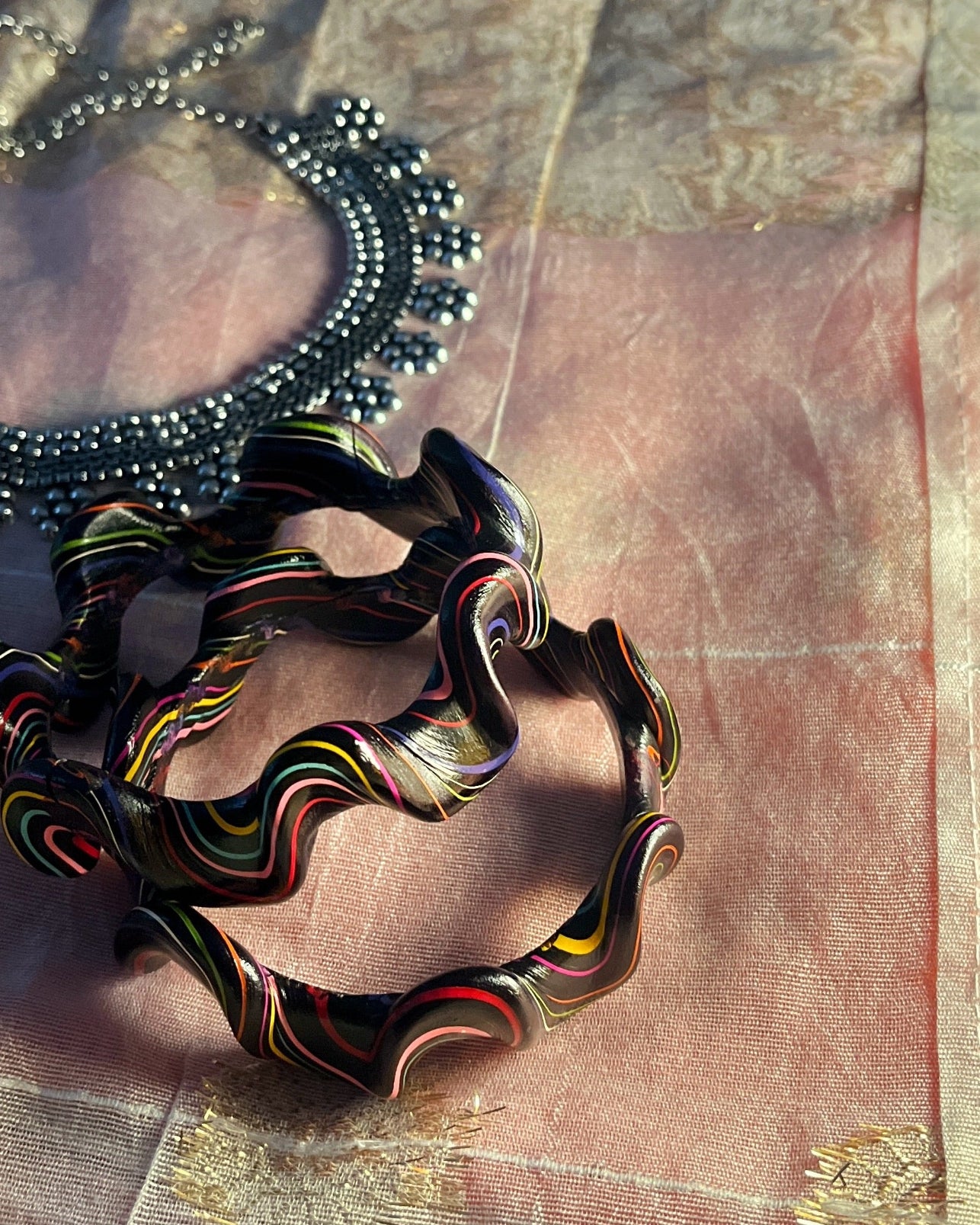 Colorful woven bracelet on a textured fabric background