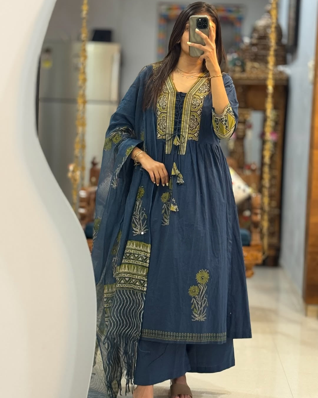 Woman taking a mirror selfie wearing a blue embroidered outfit with a matching dupatta.