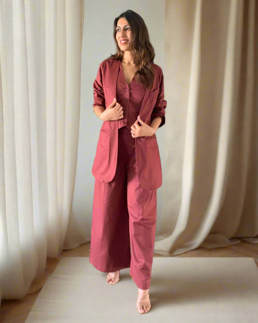 Woman in a maroon outfit standing in a room with decorative vases.