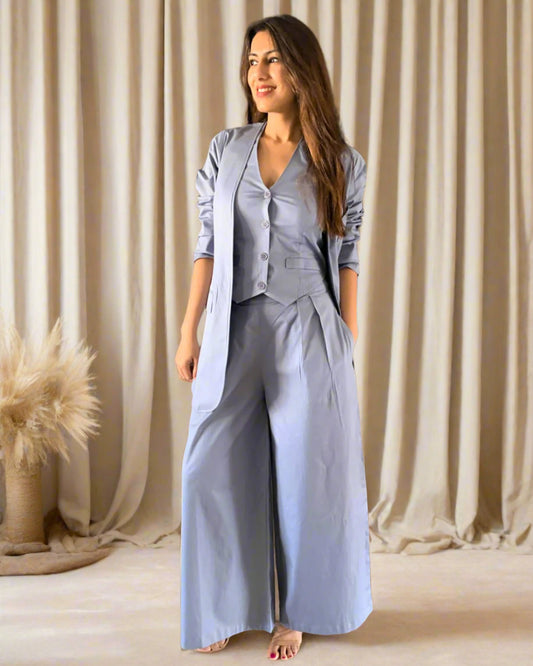 Woman wearing a light blue outfit standing in an indoor setting with wooden elements.