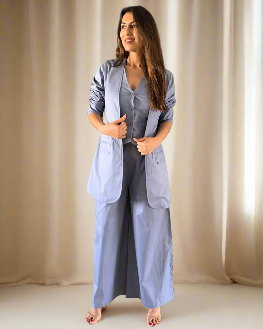 Woman in a light blue outfit standing in a room with decorative elements.