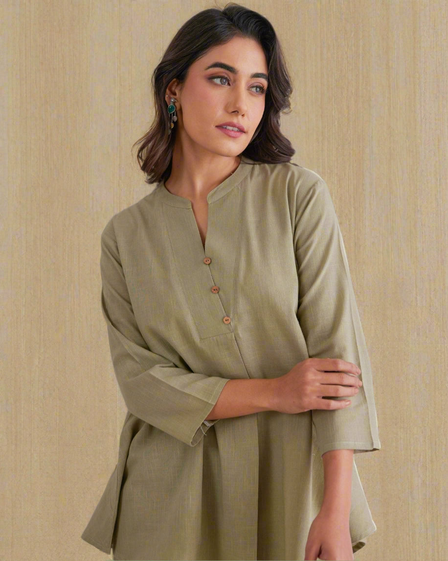 Woman wearing a green outfit against a light background