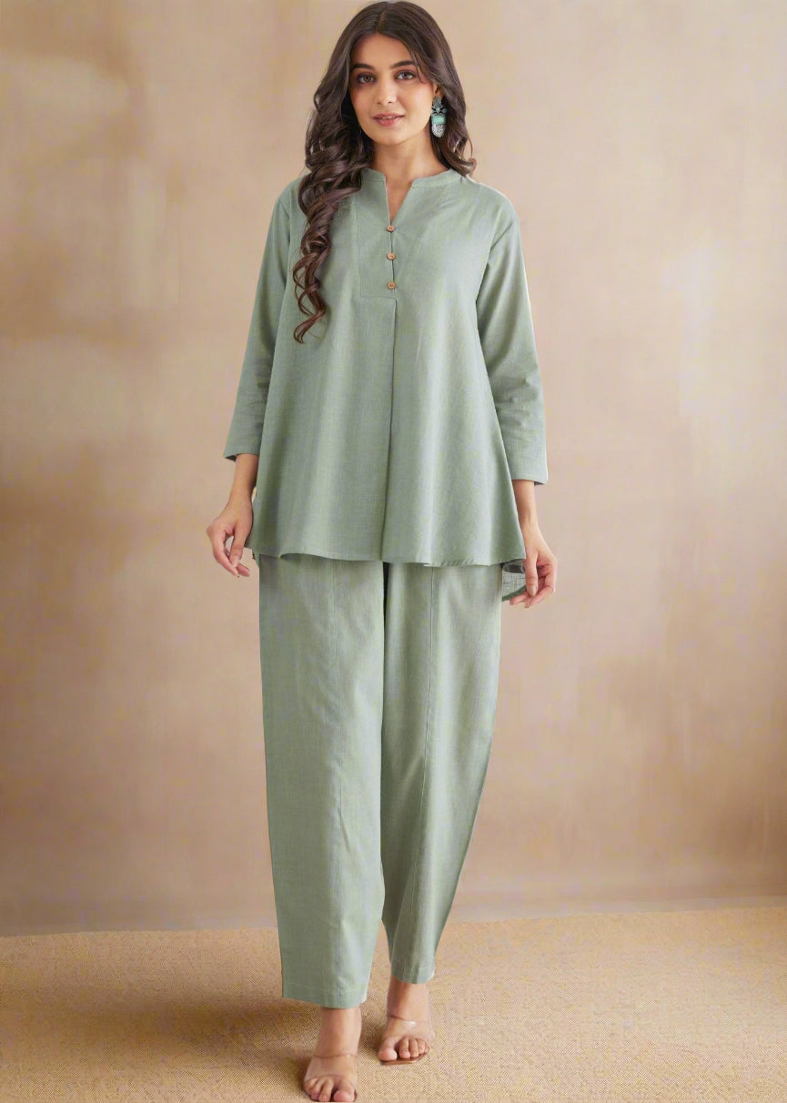 Woman wearing a green outfit against a white floral background