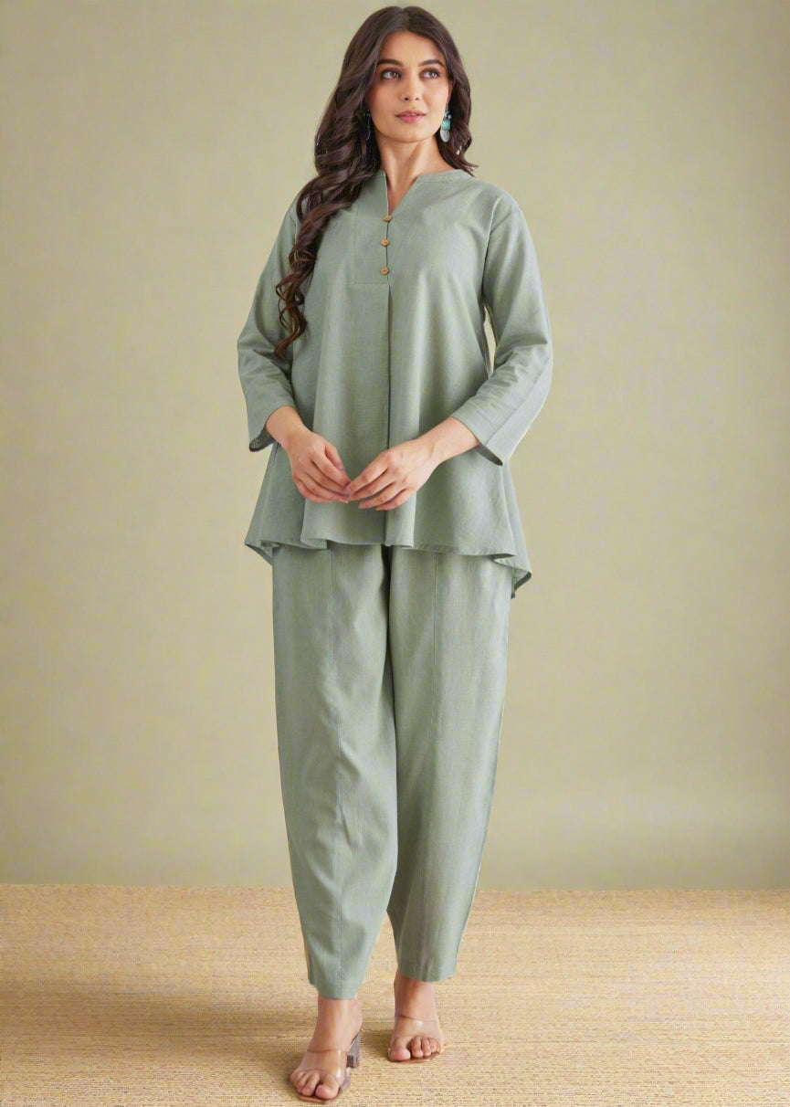 Woman wearing a green outfit against a white background with leaf patterns