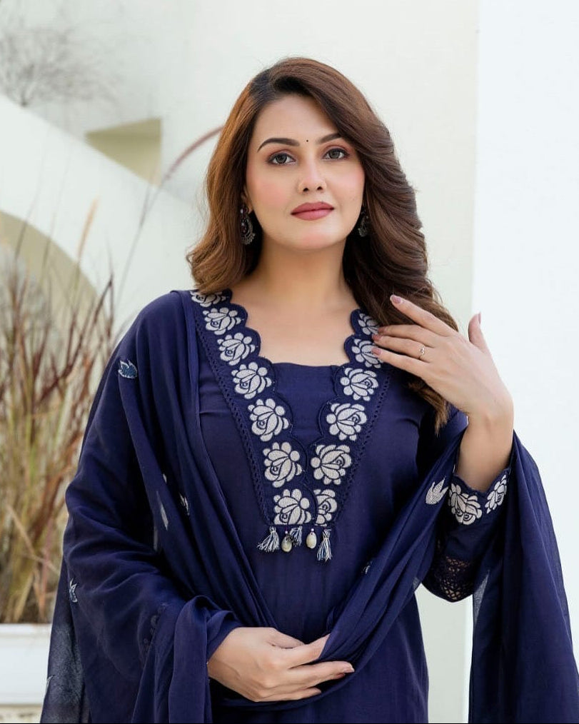 Woman wearing a navy blue embroidered outfit with a white background