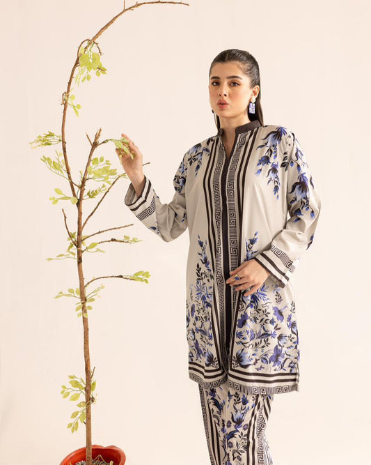Woman in a floral outfit holding a small tree against a plain background